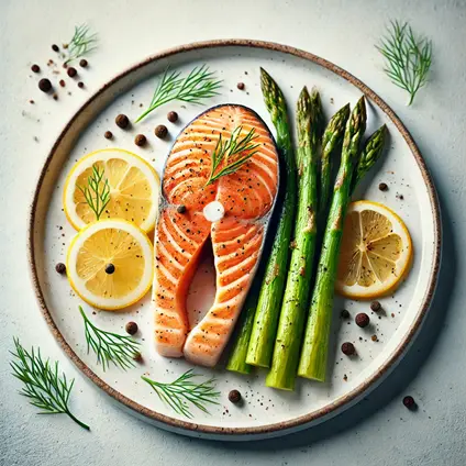 Baked salmon fillet with roasted asparagus, garnished with a lemon slice and fresh dill on a white plate.